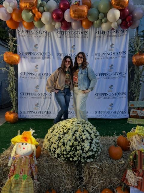 Two women standing in front of backdrop for photo